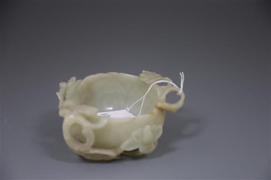 A Chinese pale celadon jade lotus cup, late Ming dynasty, W.13cm, associated wood stand
